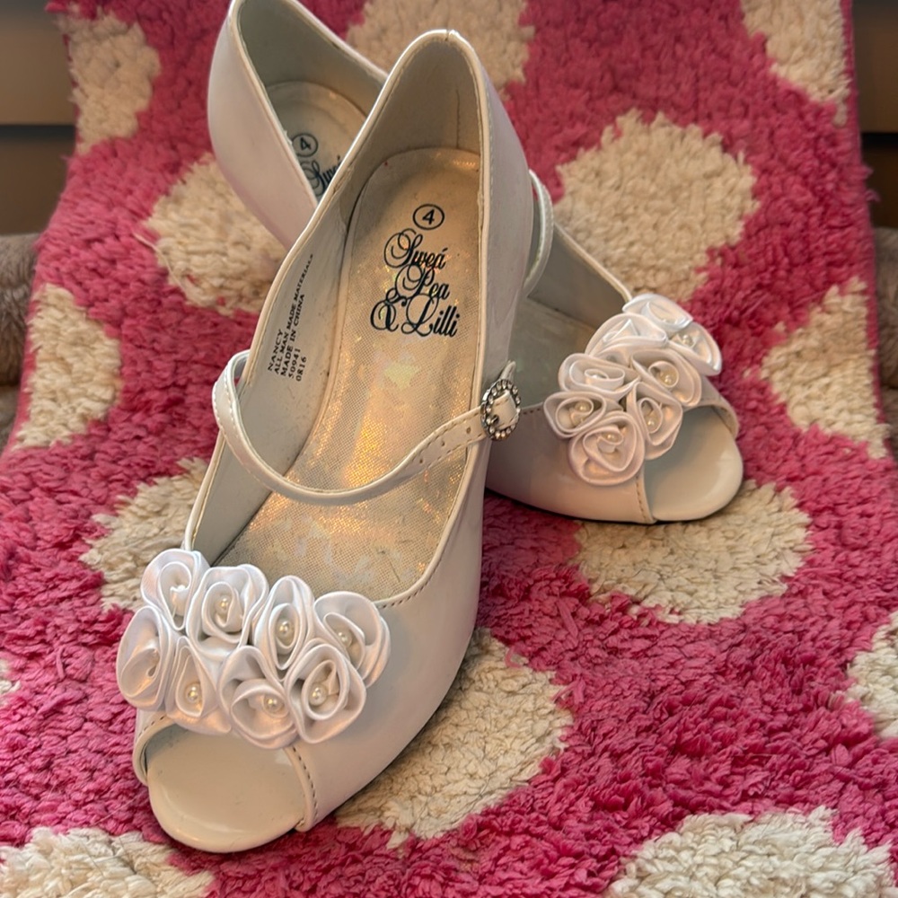 White patent leather shoes with floral appliqué.